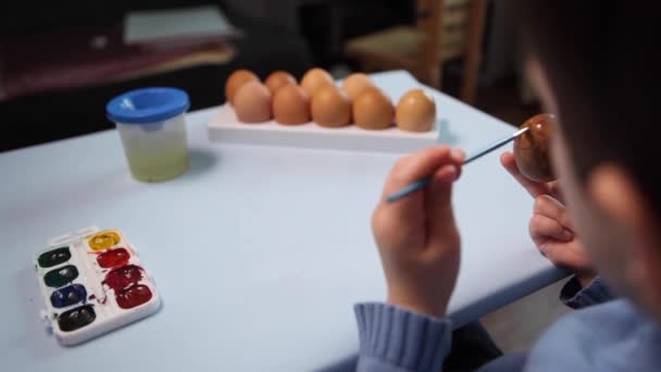 Bambino Dipinge Uovo Pasqua Tavola Uno Sfondo Azzurro Bambino Che — Video Stock