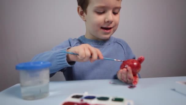 Little Child Paints Easter Egg Table Blue Background Little Boy — Stock Video