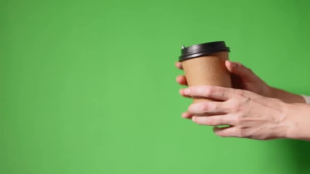2つのコーヒー特別オファーまたはプロモーション 緑色の画面の背景に2つのカップを保持手 紅茶やコーヒーを移動します 黒蓋の茶色い紙コップ — ストック動画