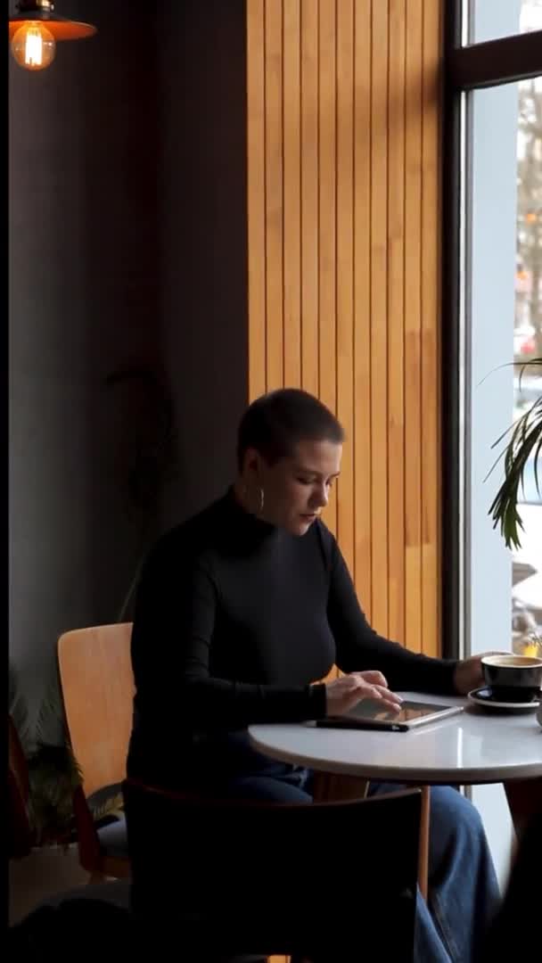 Junges Mädchen Mit Kurzen Haaren Und Nasenpiercing Sitzt Einem Café — Stockvideo