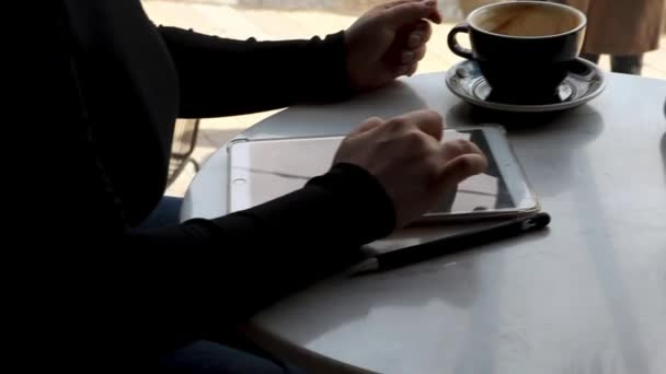 头发短且鼻孔突出的小女孩坐在咖啡店里 在平板电脑前工作 自由职业和远程工作的概念 一个女人喝着咖啡 用笔在图形石板上画画 — 图库视频影像