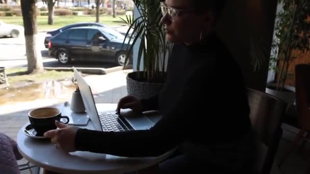 Nuori Tyttö Jolla Lasit Lyhyet Hiukset Nenälävistys Istuu Kahvilassa Työskentelee — kuvapankkivideo