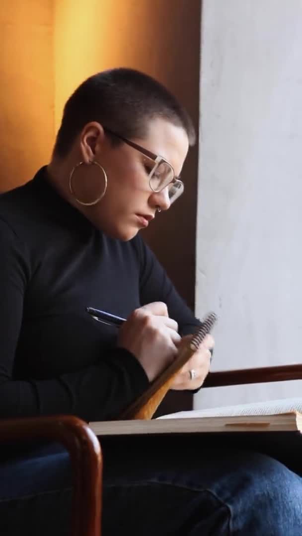 Uma Jovem Com Óculos Com Cabelo Curto Está Sentada Café — Vídeo de Stock