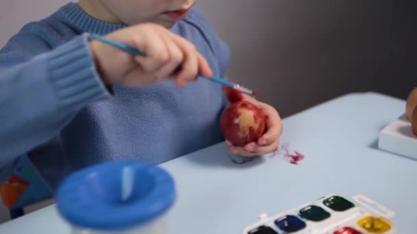 Ένα Μικρό Παιδί Ζωγραφίζει Ένα Πασχαλινό Αυγό Στο Τραπέζι Μπλε — Αρχείο Βίντεο