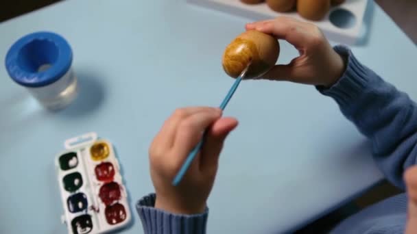 Malé Dítě Maluje Velikonoční Vajíčko Stolu Modrém Pozadí Malý Chlapec — Stock video