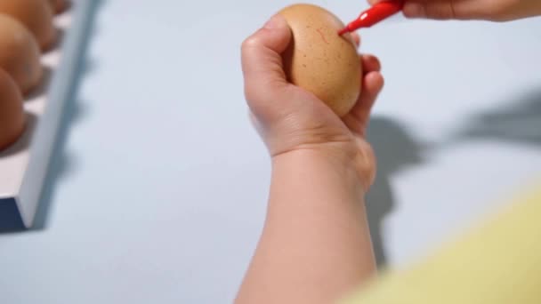 Маленька Дитина Малює Великодні Яйця Столом Синьому Фоні Маленький Хлопчик — стокове відео