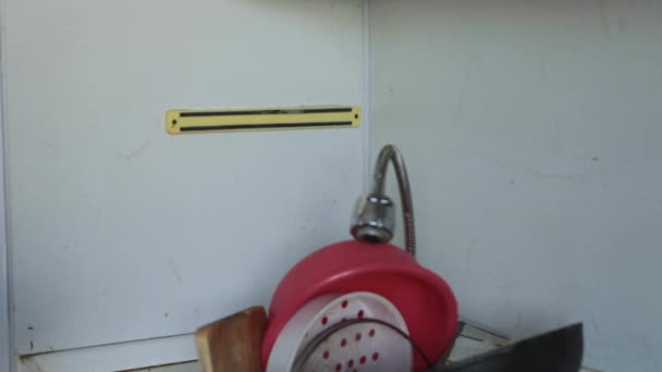 一个穿着围裙和橡胶手套的女人在厨房的水槽里洗脏东西 洗碗槽里的脏盘子 — 图库视频影像