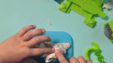 Çocuk balçıktan heykel yapıyor. Çocuklar için sanat aktivitesi, çocuklar için ev eğlencesi. Yaklaş ve odaklan, yüz ve eller. Evde ya da okulda çocuk aktiviteleri için eğlence zamanı.