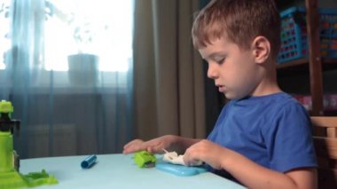 Çocuk balçıktan heykel yapıyor. Çocuklar için sanat aktivitesi, çocuklar için ev eğlencesi. Yaklaş ve odaklan, yüz ve eller. Evde ya da okulda çocuk aktiviteleri için eğlence zamanı.