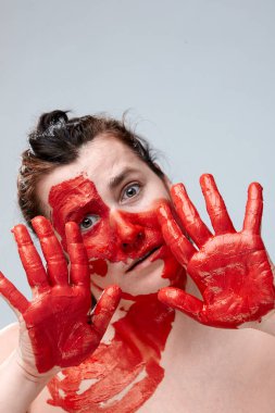 Yüzü boyalı bir kadın portresi. Yaratıcı makyaj ve parlak stil. Yüzü renkli bir kız. Sanat güzelliği. Yüzünde renkli boya olan bir kız.. 