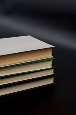 Bir sürü renkli kitap yığını. Bir kitap yığını üzerinde açık bir kitap. Eğitim konsepti, uluslararası kitap günü, başarı. Kitap, sert ciltli renkli kitaplar masada. Eğitim sektörü kavramı.