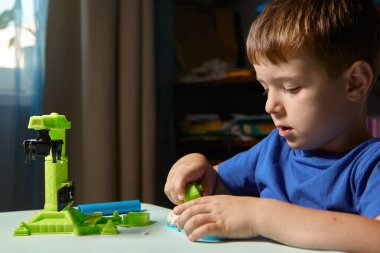 Çocuk balçıktan heykel yapıyor. Çocuklar için sanat aktivitesi, çocuklar için ev eğlencesi. Yaklaş ve odaklan, yüz ve eller. Evde ya da okulda çocuk aktiviteleri için eğlence zamanı.