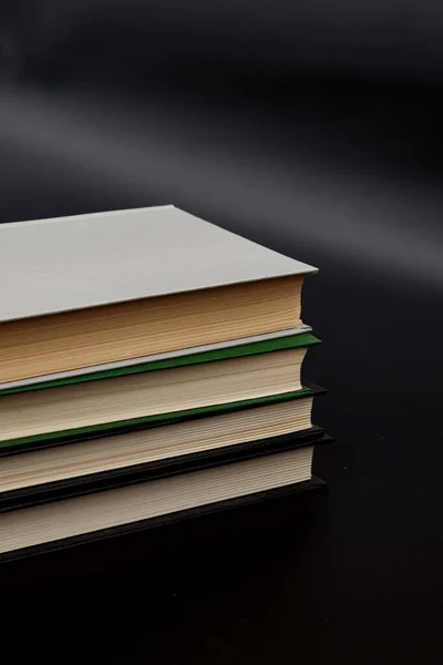 Stack of colorful books. An open book on a stack of books. The concept of education, international book day, success. Book, hardback colorful books on table. Education business concept.