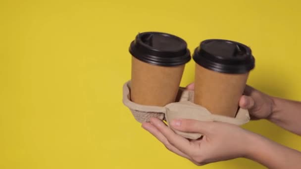 Närbild Gul Bakgrund Kvinnors Händer Håller Två Papperskoppar Med Kaffe — Stockvideo