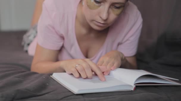 Una mujer en casa leyendo un libro — Vídeos de Stock