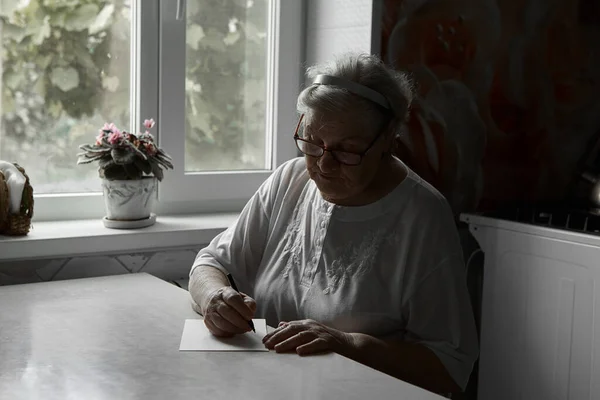 Eine Ältere Frau Schreibt Hause Auf Einen Zettel Hobbys Von — Stockfoto