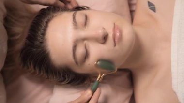 Genç ve güzel bir kadın, sağlık merkezinde boyun masajı yaptırıyor. Masör, kaplıca salonundaki genç ve güzel bir kızın kafasına masaj yapıyor. Makroyu kapat. 