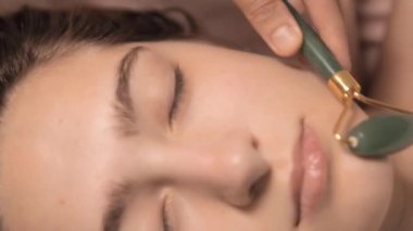 Genç ve güzel bir kadın, sağlık merkezinde boyun masajı yaptırıyor. Masör, kaplıca salonundaki genç ve güzel bir kızın kafasına masaj yapıyor. Makroyu kapat. 