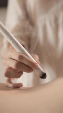 Alternatif terapist geleneksel Çin tıbbı yöntemini uyguluyor. Geleneksel Asya tıbbı ile genç bir hastayı iyileştiren doktor. Moxa tek başına. Aşırı yakın çekim. Moxibustion.