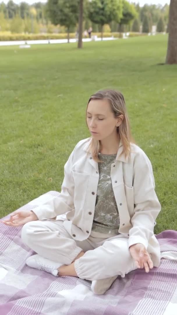 Kvinnan Sitter Lotusställning Korsad Benhållning Sukhasana Och Mediterar Park Attraktiv — Stockvideo