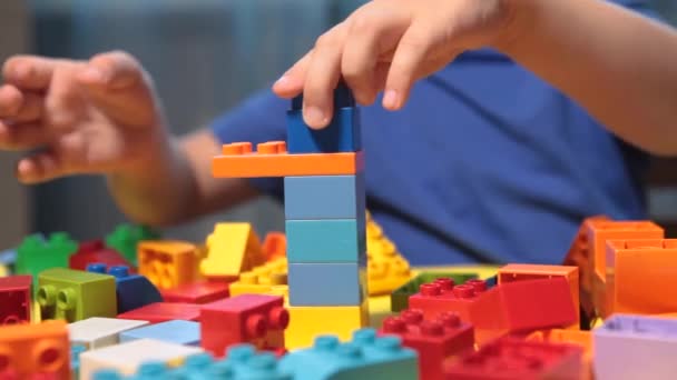 Un niño juega un constructor brillante — Vídeos de Stock