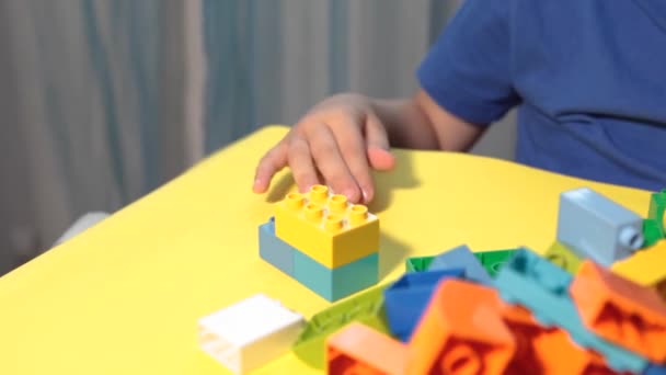 Seorang anak laki-laki memainkan konstruktor cerah — Stok Video