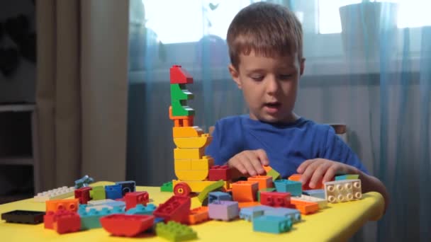 Un niño juega un constructor brillante — Vídeos de Stock