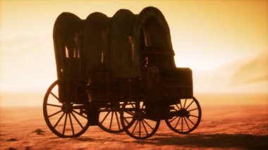 Çölde gün batımında eski arabaları kaplayan tuval.