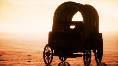 Çölde gün batımında eski arabaları kaplayan tuval.