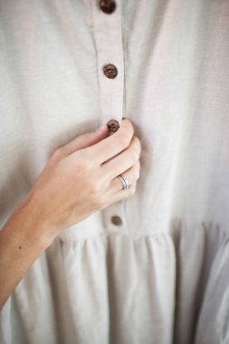 Hindistan cevizi ahşap düğmesi, keten keten elbisenin üstünde.