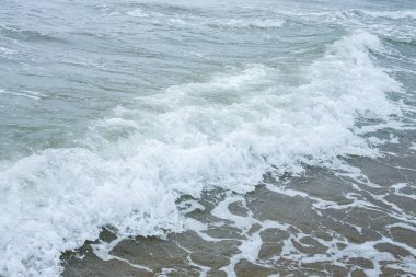 Deniz kıyısında küçük dalgalar, köpüren dalgalar.