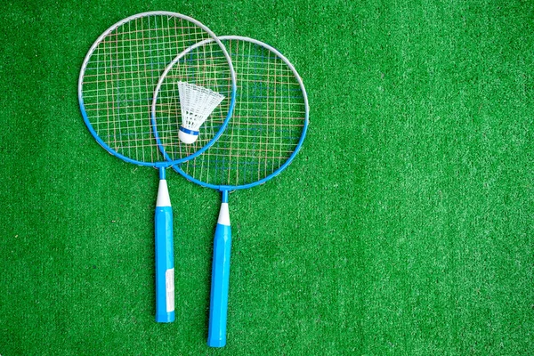 Two badminton mini rackets with white shuttlecock on the green background, active games. copy space.