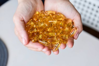 Omega-3 balık yağı kapsüllerini tutan eller. Sağlık sigortası, sağlıklı beslenme destek konsepti. Vitamin hapları.