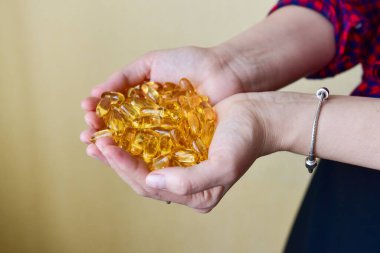 Omega-3 balık yağı kapsüllerini tutan eller. Sağlık sigortası, sağlıklı beslenme destek konsepti. Vitamin hapları.