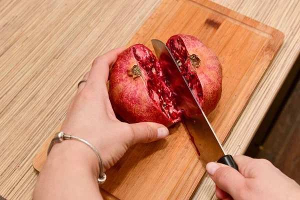 Mãos Femininas Cortando Romã Uma Placa Corte Madeira Uma Cozinha — Fotografia de Stock