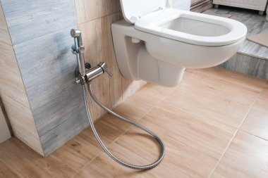 Beyaz, tuvalet ya da krom duş başlıklı bide ile modern banyo iç tasarımı.