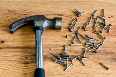 Tahta bir masada çivili metal çekiç. Kapatın. Marangoz konsepti.