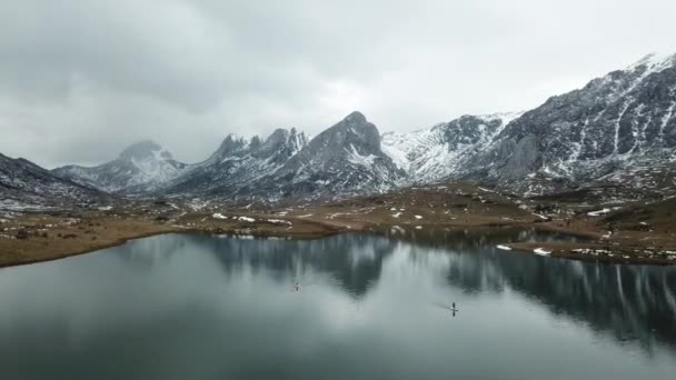 Paddle surf en un lago nevado de montaña. Vista del dron — Vídeos de Stock