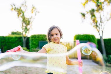 Su kabarcıklarıyla oynayan kız