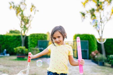 Su kabarcıklarıyla oynayan kız