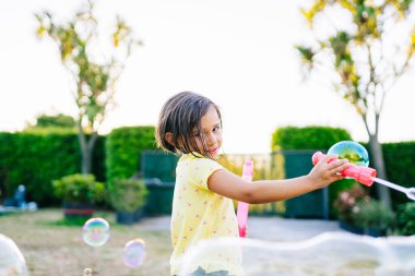 Su kabarcıklarıyla oynayan kız