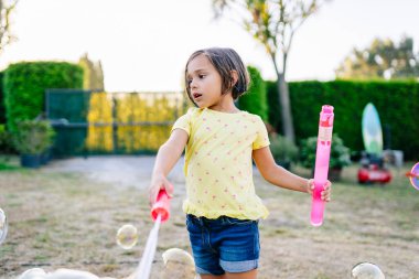 Su kabarcıklarıyla oynayan kız