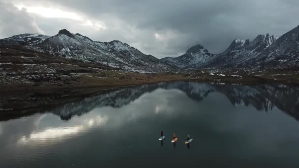 Відео деяких людей весло серфінг на гірському озері взимку — стокове відео