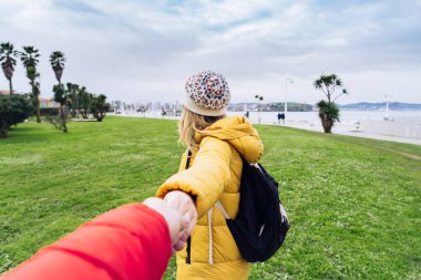 Bir parkın arka planında el ele tutuşan kadın