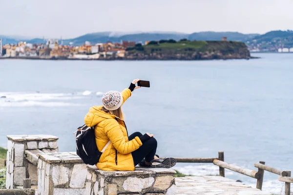 Bir kadın telefonla selfie çekiyor.