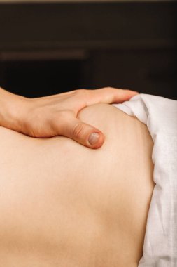 Erkeklerin yanında duran bir masörün eli. Sıcak renklerde fotokopi çekilen bir masaj terapistinin başparmağı. Masaj salonu için.