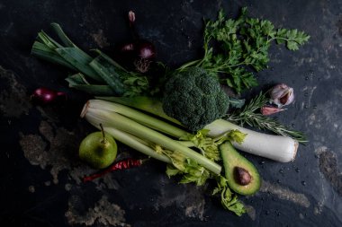 yeşil sebzeler masanın üstünde.