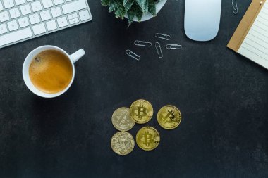 Düz görünüm ofis masası klavye ve akıllı telefon, saat, bitki, kahve ve kara arka planda bitcoin ile çalışma alanı yatıyordu
