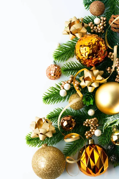 Fragment of a Christmas tree with gold balls and Christmas decor on a white background with space for writing text.