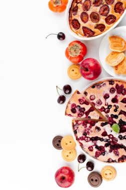 Erikli kek, meyveli turta, kurabiyeler ve meyveler yazı yazmak için boş bir arkaplan üzerine yerleştirilir.